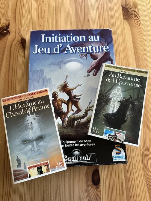 Une boîte d'initiation au jeu de rôle L’œil noir et deux livres dont vous êtes le héros : L'homme au cheval de brume et Au royaume de l'épouvante.